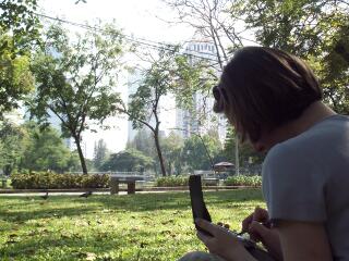 Jeanie in Lumphini Park, Bangkok, using the PDA to update the webpage.